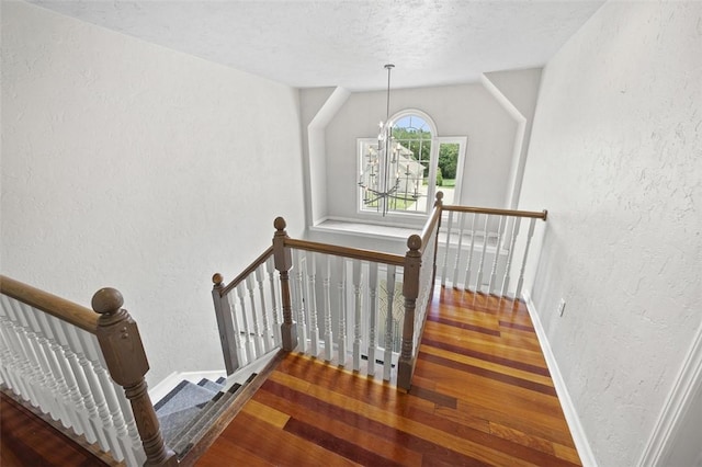 1007 Cicero Dr, Hempfield Twp, PA 15642 - staircase with a textured wall, wood finished floors, a chandelier, and a textured ceiling