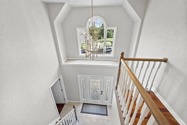 1007 Cicero Dr, Hempfield Twp, PA 15642 - staircase with a chandelier, tile patterned flooring, a textured wall, and lofted ceiling