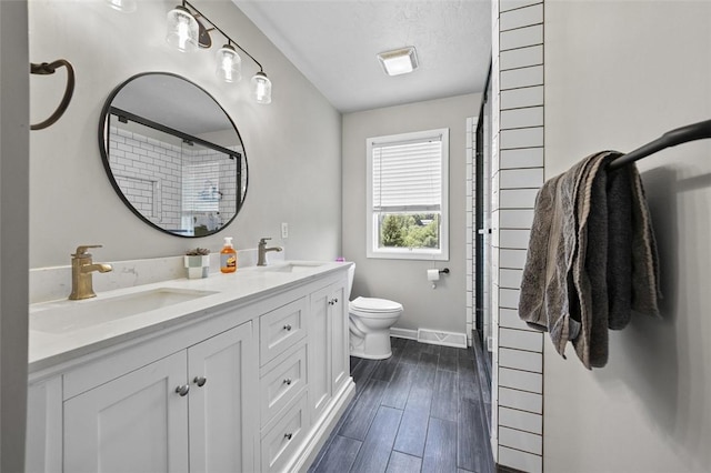 1007 Cicero Dr, Hempfield Twp, PA 15642 - bathroom with double vanity, a shower, wood finish floors, and a textured ceiling