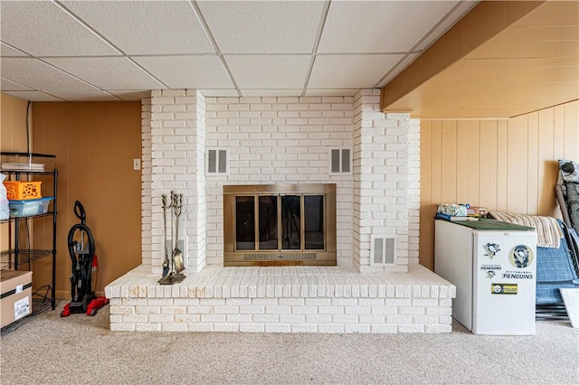 209 Farmbrook Dr, Hempfield Twp, PA 15601 - carpeted living area featuring a brick fireplace, a paneled ceiling, and wooden walls