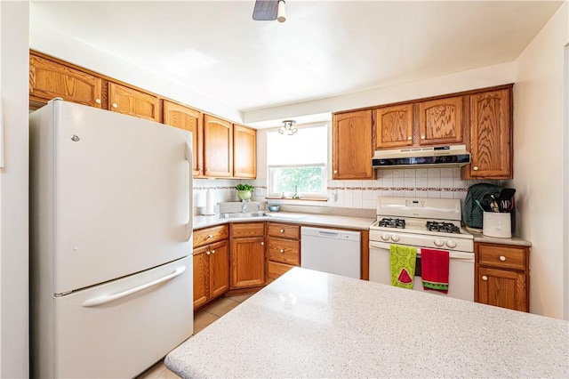 209 Farmbrook Dr, Hempfield Twp, PA 15601 - kitchen with white appliances, under cabinet range hood, decorative backsplash, light countertops, and brown cabinets