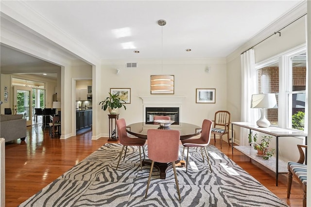 13 Kings Ln, Pine Twp, PA 16127 - dining space with wood finished floors, a glass covered fireplace, and crown molding