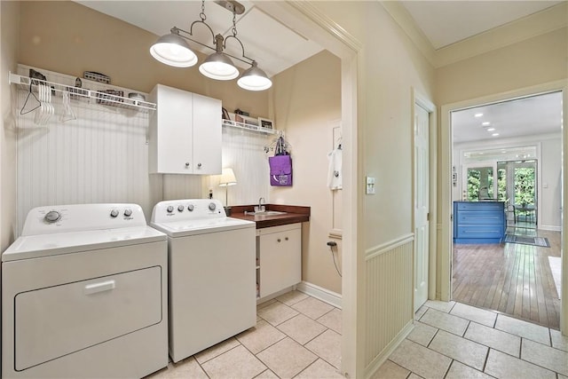13 Kings Ln, Pine Twp, PA 16127 - washroom with cabinet space, washing machine and dryer, light tile patterned floors, and a wainscoted wall