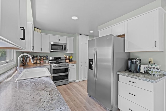 249 Duquesne Blvd, Plum Boro, PA 15068 - kitchen with appliances with stainless steel finishes, light wood-style flooring, white cabinets, recessed lighting, and light stone counters