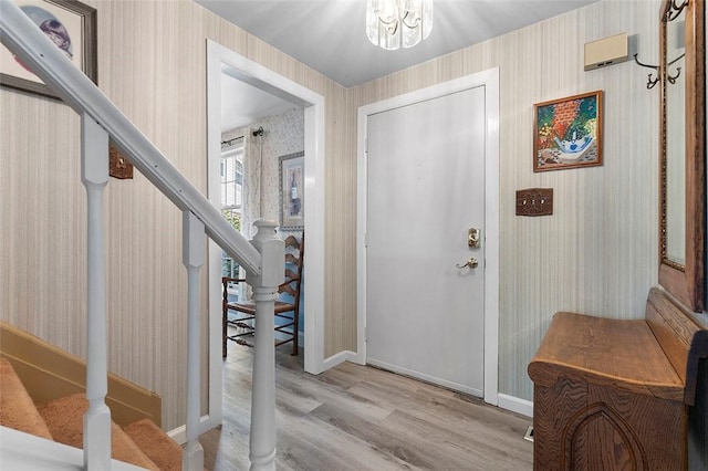 249 Duquesne Blvd, Plum Boro, PA 15068 - foyer featuring wallpapered walls, light wood-style floors, stairs, and a chandelier