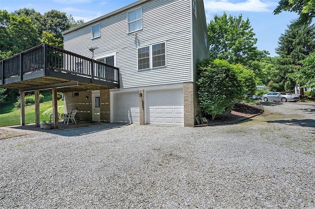 249 Duquesne Blvd, Plum Boro, PA 15068 - view of side of home featuring an attached garage, a deck, and gravel driveway