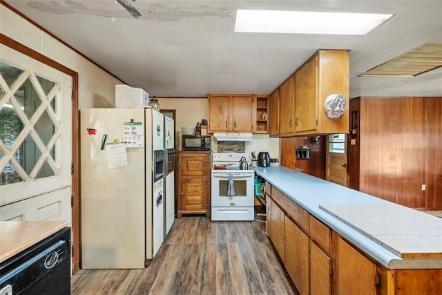 2158 Reis Run Rd, Franklin Park, PA 15237 - kitchen with black appliances, dark wood-style flooring, a peninsula, brown cabinets, and under cabinet range hood