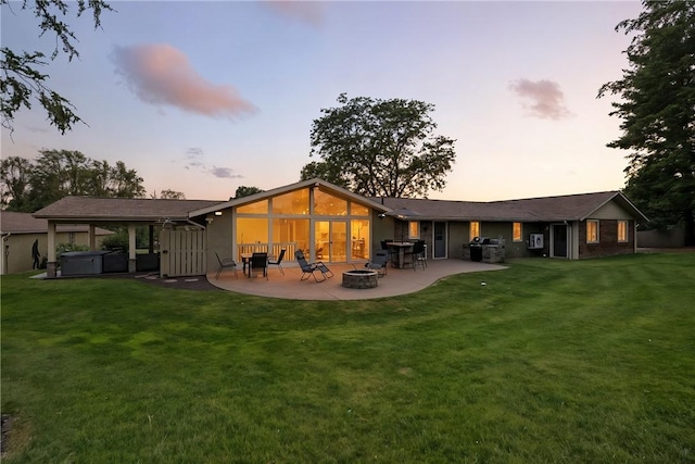 251 Myers Ln, Indiana Twp, PA 15101 - back of house at dusk featuring a hot tub, an outdoor fire pit, a patio, and a lawn