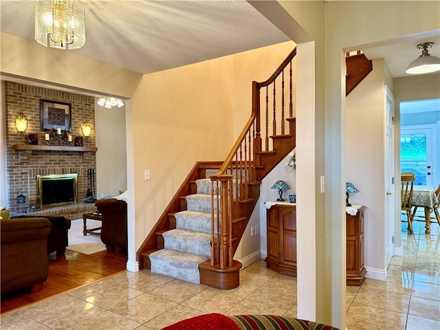 293 Sandy Hill Rd, Middlesex Twp, PA 16059 - stairs featuring a chandelier, a fireplace, and tile patterned floors
