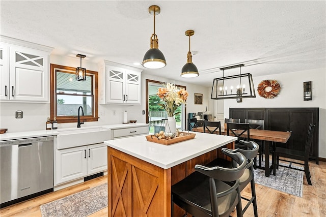 314 Shannon Cir, Daugherty Twp, PA 15066 - kitchen featuring dishwasher, light wood-style floors, white cabinetry, decorative light fixtures, and a kitchen island