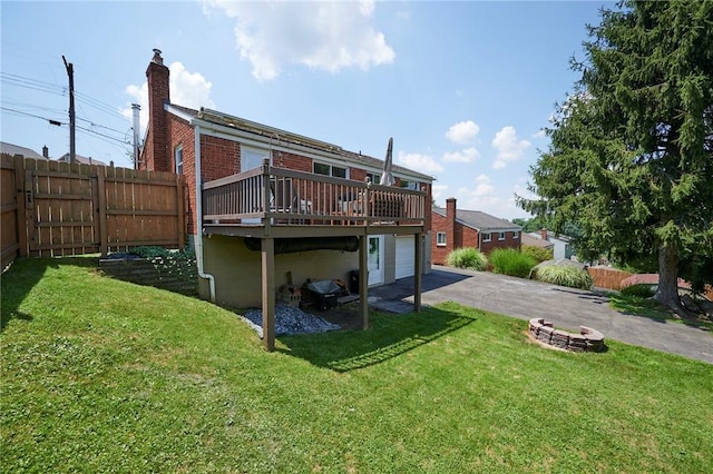 1023 Bellair Rd, Port Vue, PA 15133 - rear view of property featuring asphalt driveway, a deck, a chimney, an attached garage, and brick siding