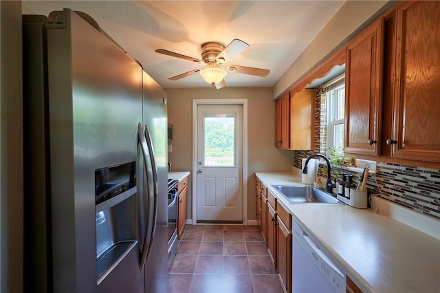 1023 Bellair Rd, Port Vue, PA 15133 - kitchen with appliances with stainless steel finishes, brown cabinets, a ceiling fan, light countertops, and decorative backsplash