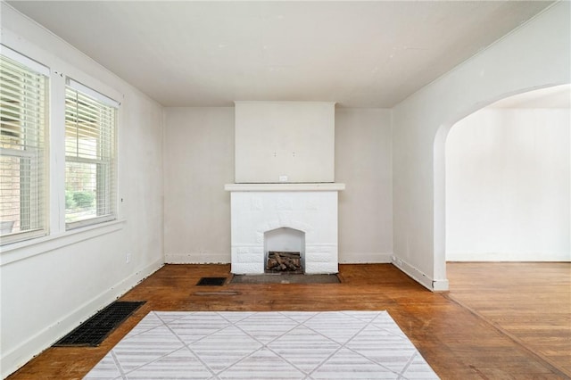 2600 Voelkel Ave, Beechview, PA 15216 - unfurnished living room featuring wood finished floors, arched walkways, and a fireplace with flush hearth