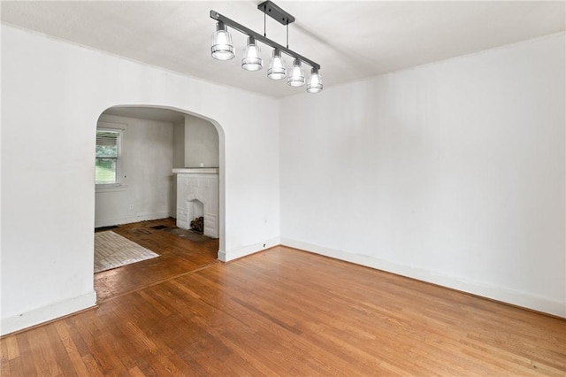 2600 Voelkel Ave, Beechview, PA 15216 - unfurnished dining area featuring wood finished floors, arched walkways, and a brick fireplace