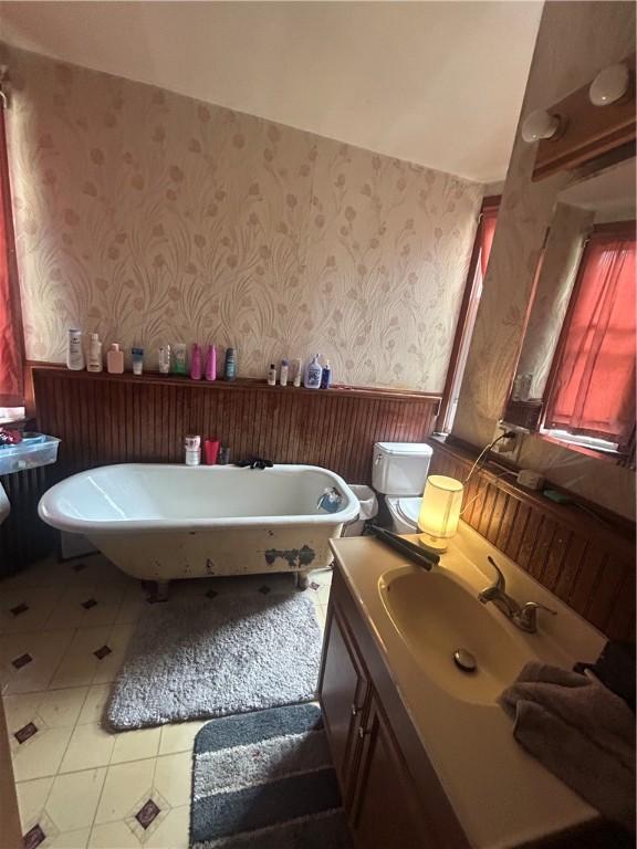 822 4th St, West Elizabeth, PA 15088 - bathroom featuring wallpapered walls, a wainscoted wall, a soaking tub, and vanity