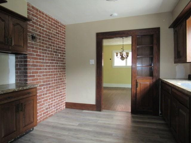409 Keystone Dr, New Kensington, PA 15068 - kitchen with a chandelier, light wood-style flooring, light stone countertops, and dark brown cabinets