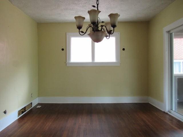 409 Keystone Dr, New Kensington, PA 15068 - empty room with a textured ceiling, wood finished floors, and a chandelier