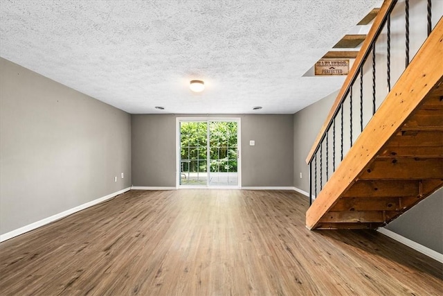 651 Newton Sq, Moon/Crescent Twp, PA 15108 - unfurnished living room with wood finished floors, stairway, and a textured ceiling