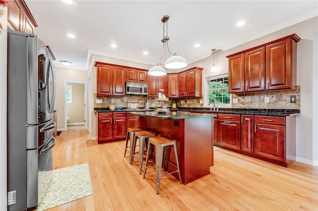 1044 Cross Creek Dr, South Union Twp, PA 15401 - kitchen featuring appliances with stainless steel finishes, ornamental molding, a center island, light wood-type flooring, and a breakfast bar