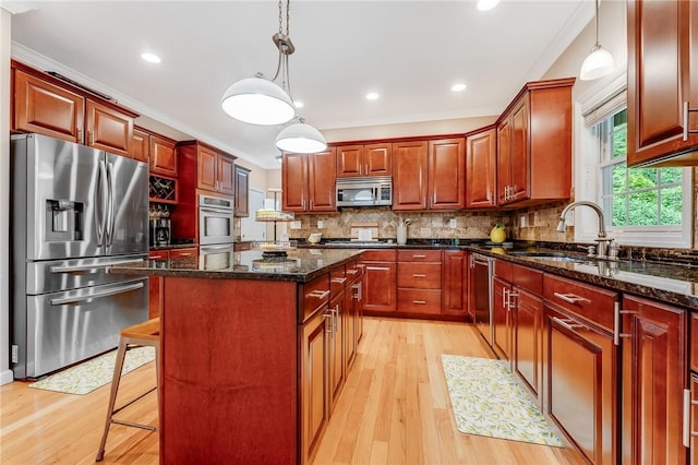 1044 Cross Creek Dr, South Union Twp, PA 15401 - kitchen with appliances with stainless steel finishes, a center island, light wood-style flooring, tasteful backsplash, and ornamental molding