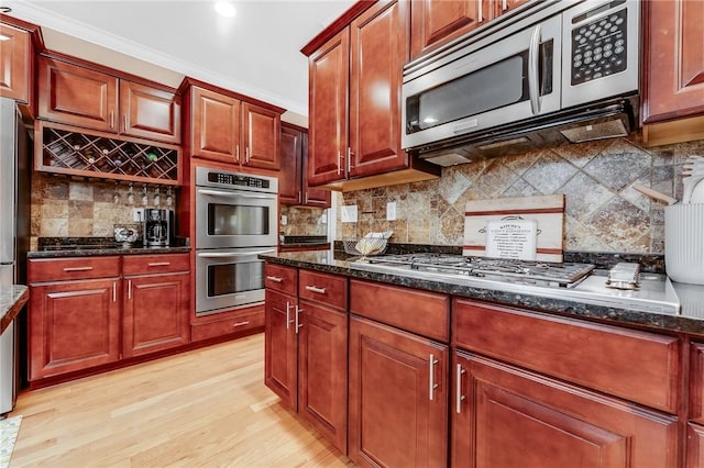 1044 Cross Creek Dr, South Union Twp, PA 15401 - kitchen with stainless steel appliances, tasteful backsplash, light wood-style flooring, ornamental molding, and dark stone countertops