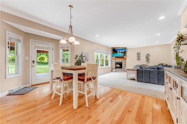 1044 Cross Creek Dr, South Union Twp, PA 15401 - dining space with light wood-style flooring, crown molding, a stone fireplace, and recessed lighting