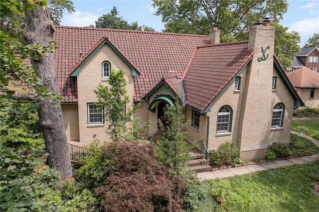 1302 Mount Royal Blvd, Shaler, PA 15223 - tudor house with a chimney, a tiled roof, and brick siding