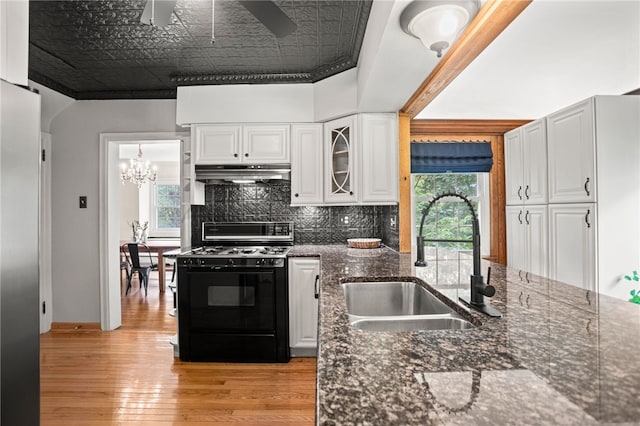 1302 Mount Royal Blvd, Shaler, PA 15223 - kitchen with gas stove, under cabinet range hood, a ceiling fan, light wood finished floors, and white cabinetry