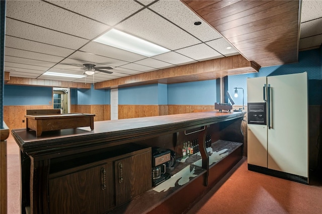1302 Mount Royal Blvd, Shaler, PA 15223 - kitchen with white refrigerator with ice dispenser, a wainscoted wall, a ceiling fan, wooden walls, and a paneled ceiling