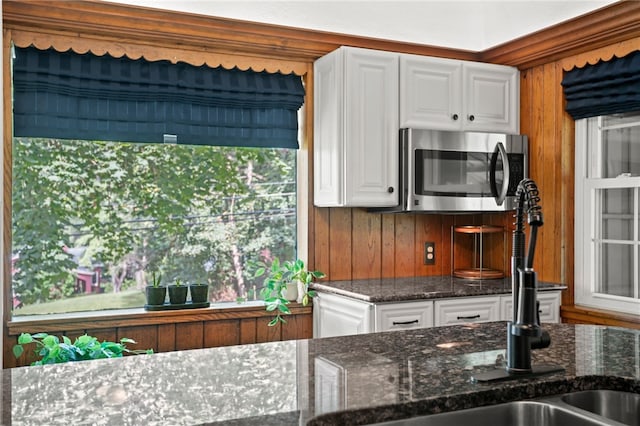 1302 Mount Royal Blvd, Shaler, PA 15223 - kitchen with stainless steel microwave, dark stone counters, white cabinets, and wooden walls