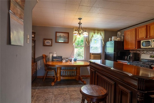 309 Francis Ave, Monongahela, PA 15063 - kitchen featuring appliances with stainless steel finishes, decorative backsplash, brown cabinets, decorative light fixtures, and cooling unit