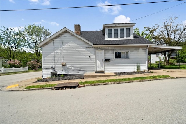 657 Grove St, City Of Greensburg, PA 15601 - view of front of house featuring an attached carport, a chimney, driveway, and roof with shingles