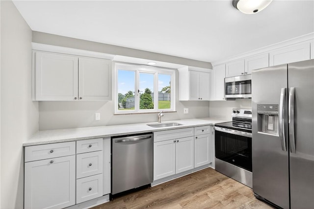 88 Pennsylvania Blvd, Monessen, PA 15062 - kitchen with stainless steel appliances, white cabinets, light wood-style floors, and light countertops