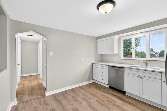 88 Pennsylvania Blvd, Monessen, PA 15062 - kitchen with dishwasher, light countertops, light wood-type flooring, arched walkways, and white cabinetry
