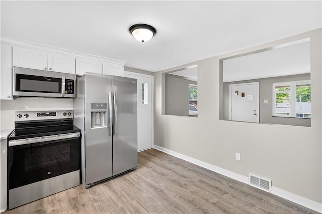 88 Pennsylvania Blvd, Monessen, PA 15062 - kitchen featuring stainless steel appliances, light wood-type flooring, white cabinets, and light countertops