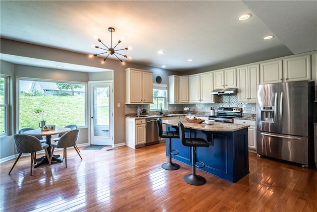 106 Kestler Dr, Pine Twp, PA 15090 - kitchen with appliances with stainless steel finishes, under cabinet range hood, hardwood / wood-style flooring, decorative backsplash, and recessed lighting