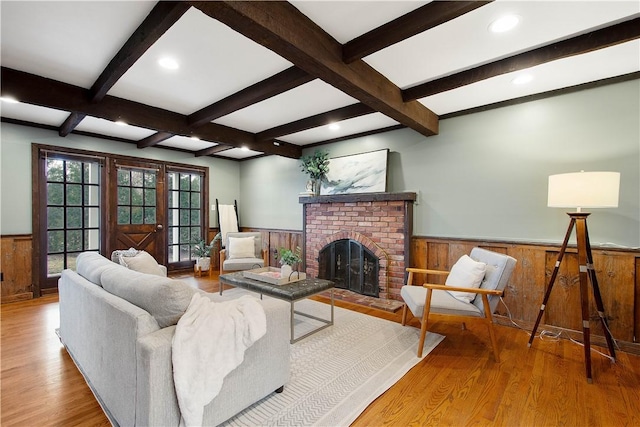 1742 Partridge Run Rd, Saint Clair, PA 15241 - living room featuring wainscoting, beam ceiling, wood finished floors, wood walls, and a brick fireplace