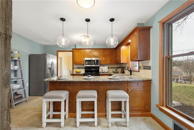 1742 Partridge Run Rd, Saint Clair, PA 15241 - kitchen with appliances with stainless steel finishes, a peninsula, plenty of natural light, and brown cabinetry