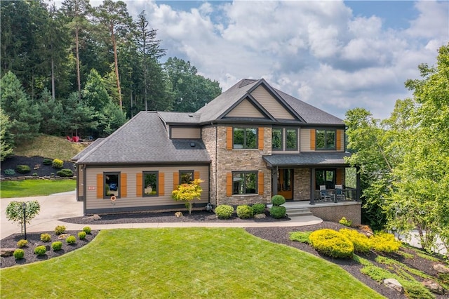 207 Tamarack Dr, Adams Twp, PA 16046 - rear view of house featuring a porch, stone siding, a yard, concrete driveway, and roof with shingles