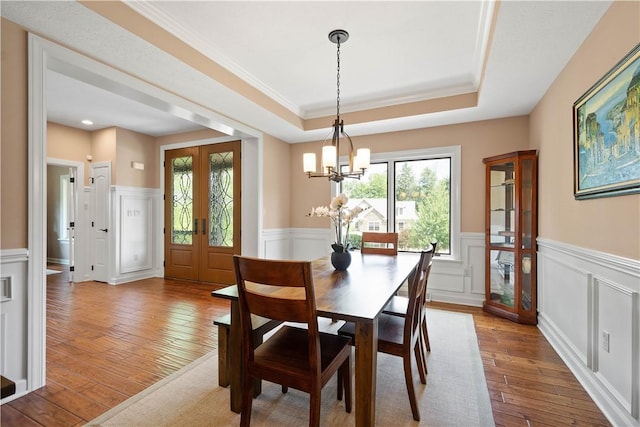 207 Tamarack Dr, Adams Twp, PA 16046 - dining space with wainscoting, a chandelier, wood-type flooring, a raised ceiling, and ornamental molding
