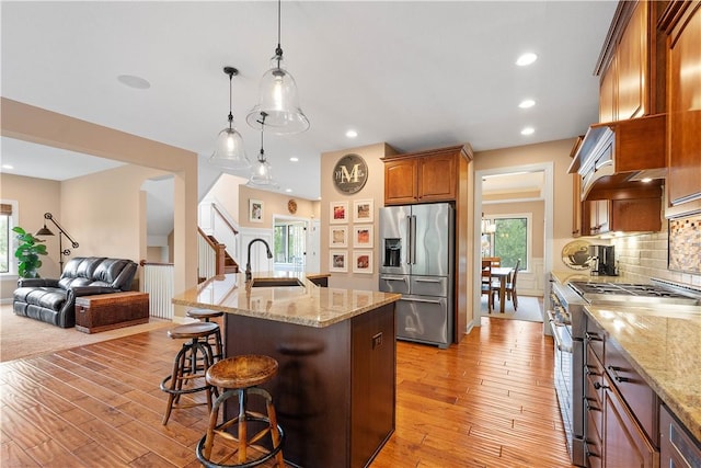 207 Tamarack Dr, Adams Twp, PA 16046 - kitchen with premium appliances, a kitchen bar, open floor plan, light wood-style floors, and recessed lighting