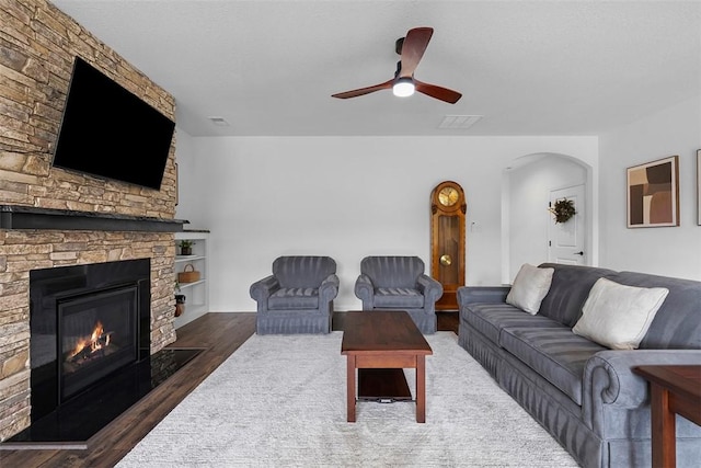 2034 Aiken Ct, Robinson Twp, PA 15136 - living area with wood finished floors, arched walkways, a ceiling fan, and a stone fireplace
