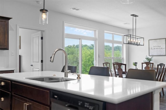 2034 Aiken Ct, Robinson Twp, PA 15136 - kitchen featuring dishwashing machine, light countertops, a chandelier, dark brown cabinets, and an island with sink