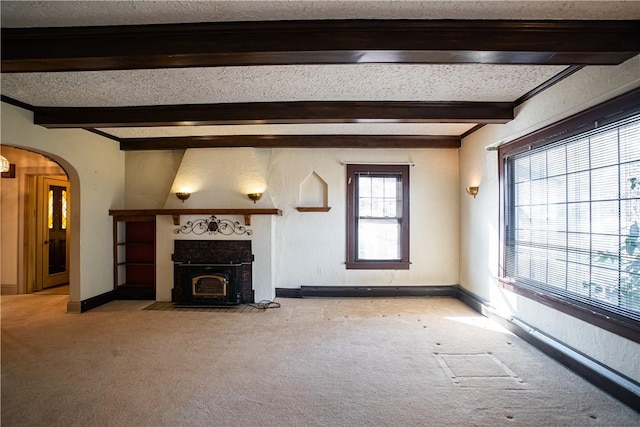 109 Maplewood Ave, Center Twp, PA 15001 - unfurnished living room with beamed ceiling, light carpet, arched walkways, a fireplace with flush hearth, and a textured ceiling