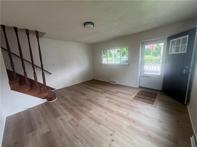 1735 Kimball Ave, New Kensington, PA 15068 - unfurnished living room with wood finished floors, stairway, and a textured ceiling