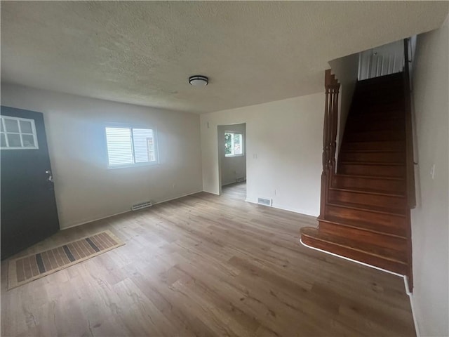1735 Kimball Ave, New Kensington, PA 15068 - spare room with wood finished floors, stairway, and a textured ceiling