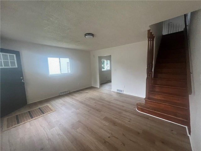 1735 Kimball Ave, New Kensington, PA 15068 - spare room with light wood finished floors, stairs, and a textured ceiling