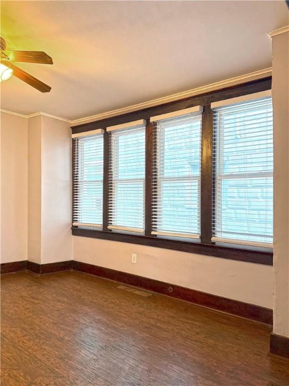 514 Linden Ave, New Kensington, PA 15068 - empty room with ornamental molding, dark wood-style flooring, healthy amount of natural light, and a ceiling fan