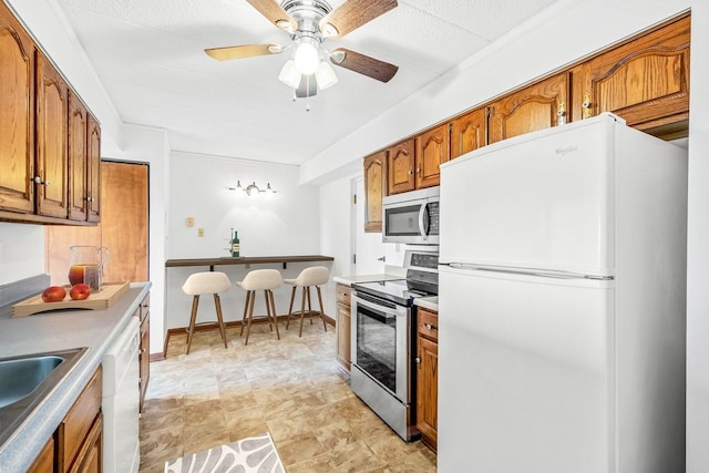 820 E Beau St Unit 6J, South Strabane, PA 15301 - kitchen featuring appliances with stainless steel finishes, brown cabinetry, and a ceiling fan