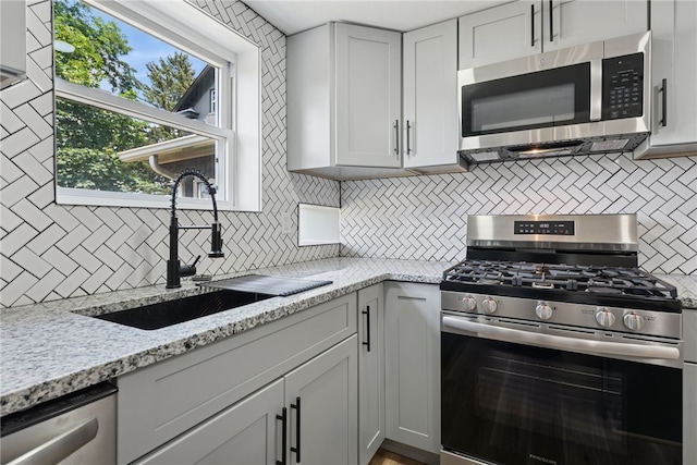 327 Charles Ave, New Kensington, PA 15068 - kitchen with stainless steel appliances, tasteful backsplash, and light stone counters